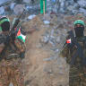 Hamas militants stand guard near a stage before releasing Israeli hostage Agam Berger to a Red Cross team in Jabalia on January 30, 2025, as part of their third hostage-prisoner exchange; illustrative