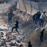 Israeli settler extremists throw stones at a dirt road at the Palestinian village of Kusra, in the West Bank, in an attempt to block the movement of Palestinians and Israeli forces, August 12, 2026