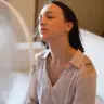 A woman sweating in front of a fan