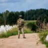A State Border Guard patrols near so-called dragon's teeth, pyramidal anti-tank obstacles of reinforced concrete used to impede the movement of military vehicles, are pictured in the area of Piedruja area.