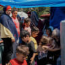 Women and children gather beside tents at a displacement camp in Zaituna Bay in central Beirut, Lebanon, May 16, 2026.