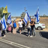 Activists from Gaza border communities demonstrate near Amitai Camp adjacent to the Kerem Shalom Crossing, blocking the road to ISF trucks in protest of their presence in the Gaza Strip. August 25, 2026.
