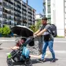 A baby in a stroller on a sunny day.