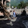 People move through a mud covered road following flash floods and a mudslide in Trishuli, Nuwakot district, Nepal, August 28, 2026.
