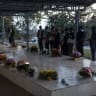 People pray by a mass grave at Nyanza Genocide Memorial Center in Kigali, Rwanda on April 11, 2024.