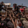 Venezuelans swarm to aid trucks where other civilians have come to deliver aid and food. 