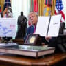 US President Donald Trump displays a signed executive order during an event in the Oval Office of the White House on August 27, 2026 in Washington, DC. 
