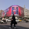 A pedestrian walks past a billboard depicting US President Donald Trump inside a catering container, installed on a building along a street in downtown of Tehran on August 31, 2026.