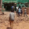 Children walk next to a collapsed mosque wall following a drone strike, in Khartoum North, in Bahri city, Sudan, August 12, 2026. 