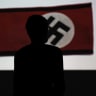 A man looks at a Nazi flag as he visits the exhibition "Design of the Third Reich" at the Design Museum Den Bosch in 's-Hertogenbosch; illustrative.