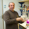 Prof. Lior David holds a small fishbowl with carps.