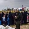Women and children queue during a joint security operation by Syria's Kurdish Internal Security Police Force, also known as Asayesh, and the Kurdish-led Syrian Democratic Forces (SDF) at Camp Roj where foreign relatives of people suspected of belonging to the Islamic State (IS) group are held.