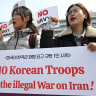 South Korean protesters hold placards during a protest against Trump's request to dispatch warships to the Strait of Hormuz in front of the US embassy in Seoul on March 16, 2026. 