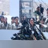 Fighters with the Kurdistan Workers' Party (PKK) line up to put their weapons into a pit during a ceremony in Sulaimaniyah, in Iraq's autonomous Kurdistan region.