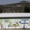 A man passes by an Israeli flag and a supermarket wall painted in the Jewish settlement of Karnei Shomron on September 9, 2026 in Karnei Shomron, West Bank. 
