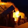People stand aboard MV June Aster as flames and smoke rise after a fire broke out on the ferry, off the coast of Palawan, Philippines.