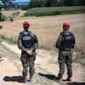 Police officers of the "Military Gendarmerie" stand guard in an area near the village of Tarnawa-Kolonia, eastern Poland, 30 July 2026, where a flying object hit the ground and exploded in the early hours of the day, the fire service reported.