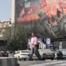 People walk past an anti-US billboard at Enghelab Square in central Tehran on September 2, 2026.