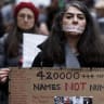 A demonstrator wears a sticker over her mouth with the words "no execution" during a silent march denouncing the Iranian government's deadly crackdown on anti-government protesters in the Islamic Republic, in Paris on January 31, 2026. 