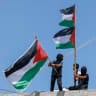  Boys wave Palestinian flags on top of a building in the village of Al-Mughayyir, east of Ramallah in the West Bank, on September 3, 2026.
