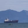 A Moroccan fisherman sails next to an oil tanker crossing the Strait of Gibraltar with the Atlas Mountains in the background, near the Spanish town of Tarifa, as seen from Tangier, Morocco, January 8, 2026.