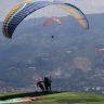 Illustrative: Paragliders run to take off from Bello, Antioquia department, Colombia on February 11, 2026.