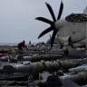 A sailor handles munitions on the flight deck of the USS George Washington in the Arabian Sea, September 13, 2026. The aircraft carrier is enforcing a US naval blockade against Iran and providing cover for commercial vessels transiting the Strait of Hormuz.