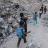 Palestinian children walk to school amid the rubble of destroyed buildings as the academic year begins in Khan Yunis, in the southern Gaza Strip on September 19, 2026. 