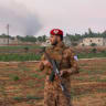 A military police officer stands on a road following an explosion at a weapons depot in the Al-Eis area, in the southern countryside of Aleppo, Syria, September 21, 2026.