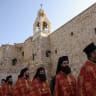 Greek Orthodox clergymen walk in a procession in the Manger Square outside the Nativity Church complex in Bethlehem in January.