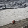 A couple stands along a river in the aftermath of the August 26 flash flood at Betrawoti Bazaar in Nepal's Nuwakot district on September 26, 2026.