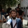 Lawrence Shenkin stands at a protest.