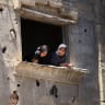 Palestinian women look from a damaged house at the site of an Israeli strike on a house that was pre-warned by the Israeli military to evacuate, before the strike was carried out late on Thursday at Shati (Beach) refugee camp, in Gaza City, May 29, 2026.