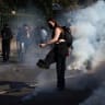 A masked students attempts to kick a tear gas canister, amid clashes with French riot police during a protest by French high school and university students near Lycee Paul Eluard high-school to demand the hiring of substitute teachers, increased resources and better learning conditions.