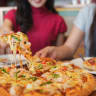 Women sit together to enjoy a pizza (illustrative)