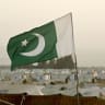 A Pakistani flag flutters in the wind.