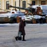 A resident walks past an exhibition of destroyed Russian military vehicles covered with snow during cold weather and often power and heating outages after critical civilian infrastructure was hit by recent Russian missile and drone strikes, amid Russia's attack on Ukraine, in Kyiv region, Ukraine. 
