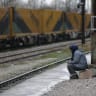A migrant woman from Afghanistan sits at the Macedonian-Serbian border near the village of Tabanovce, Macedonia February 24, 2016.