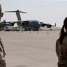 US military officers stand near US Air Force planes, which were used to evacuate people from Afghanistan, at Al Udeid airbase in Doha, Qatar, September 4, 2021. 