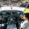 (Illustrative) People sit in the cockpit of a FlyDubai 737 Max on display at Al-Maktoum International Airport during the Dubai Airshow 2025 in Dubai on November 20, 2025. 