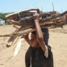 An internally displaced Yemeni boy carries sticks of firewood on his head at a makeshift camp for the internally displaced who fled their homes due to renewed clashes between Yemen's Saudi-backed government forces and the Houthi authorities in the northern Hajjah governorate on October 7, 2026.