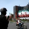 A member of a police force stands guard on a street, amid the U.S.-Israeli conflict with Iran, in Tehran Wednesday, 1st April 2026