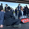 Ultra-Orthodox protester holding a sign reading "Either Haredi or the army" during an anti-draft protest on Highway 4, October 8, 2026.