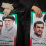 Posters featuring portraits of the late Alireza Tangsiri and Ayatollah Ali Khamenei are held by attendees of a funeral procession for IRGC Navy Chief Alireza Tangsiri, alongside other senior naval commanders and their families who were killed in US-Israeli strikes in late March, on April 1, 2026.