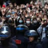 Students raise their hands in front of Police officers as they demonstrate outside Sciences Po during a protest over school overcrowding and decay on October 7, 2026 in Paris, France.