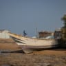 A man stands near boats that ferried people fleeing clashes between Houthi fighters and Saudi-backed Yemeni government forces, at the shores of Khor Angar near Obock on the northern shore of the Gulf of Tadjoura, opening out into the Gulf of Aden, in Djibouti, September 16, 2026.