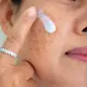 A woman with pigmentation applying cream.