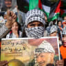 Palestinian children hold placards with a portrait of Yasser Arafat during a rally by Fatah supporters marking the 21th death anniversary of the late former Palestinian president, in the West Bank city of Hebron, November 11, 2025.