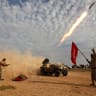 Shi'ite fighters launch a rocket during clashes with Islamic State militants on the outskirts of al-Alam, Iraq.