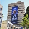 A giant poster of Israeli Prime Minister and Likud party chairman Benjamin Netanyahu bearing the words “We Will Not Surrender” is displayed on a building in Tel Aviv as part of the Likud party’s campaign ahead of the upcoming general elections, September 24, 2026. 